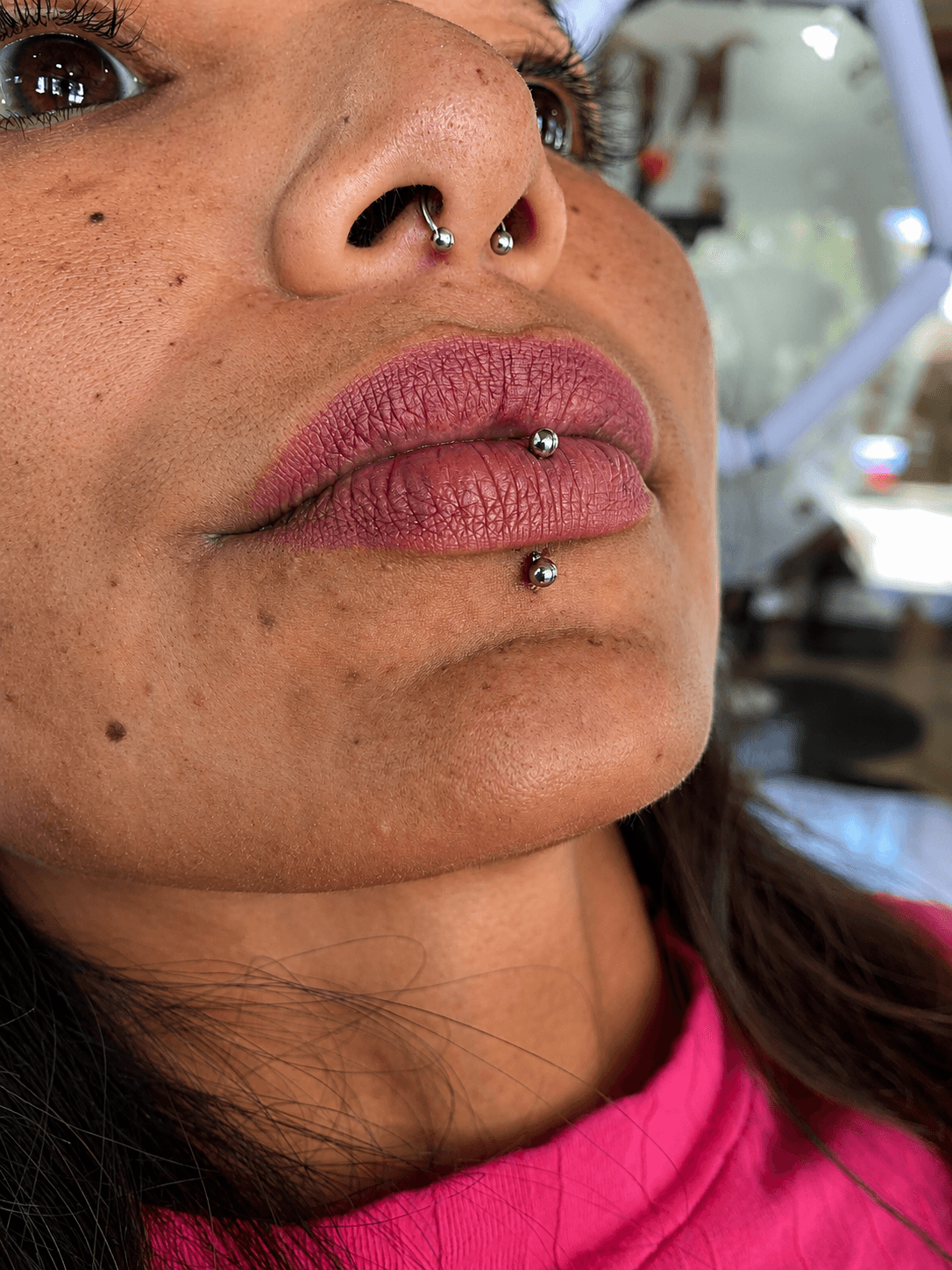 Piercing septum y labret con joyería plateada realizado por Mambas