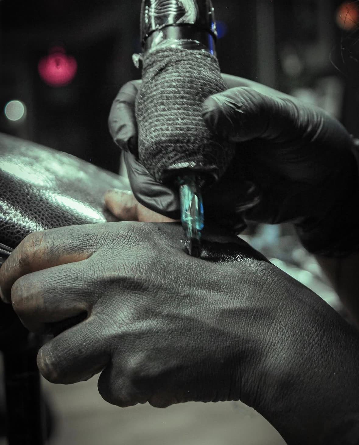 Detalle de máquina de tatuar trabajando durante una sesión en Mambas